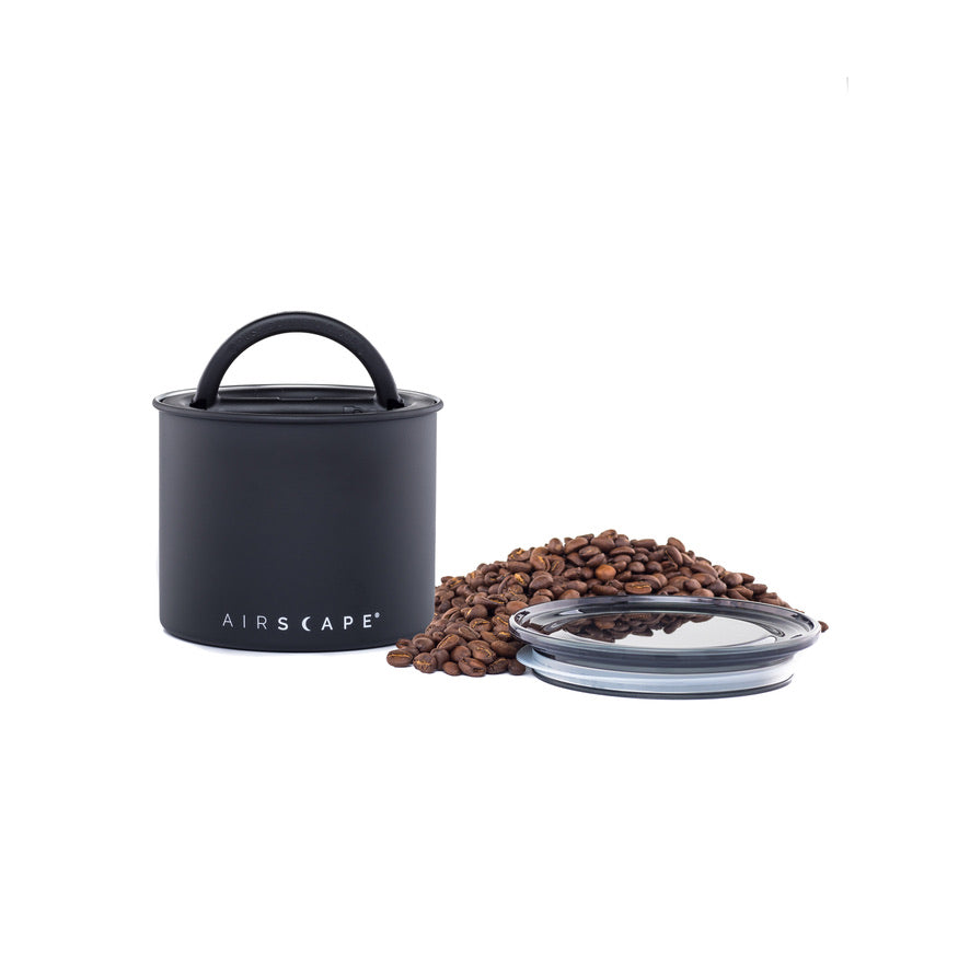 Black coffee storage container with lid and coffee beans on a white background