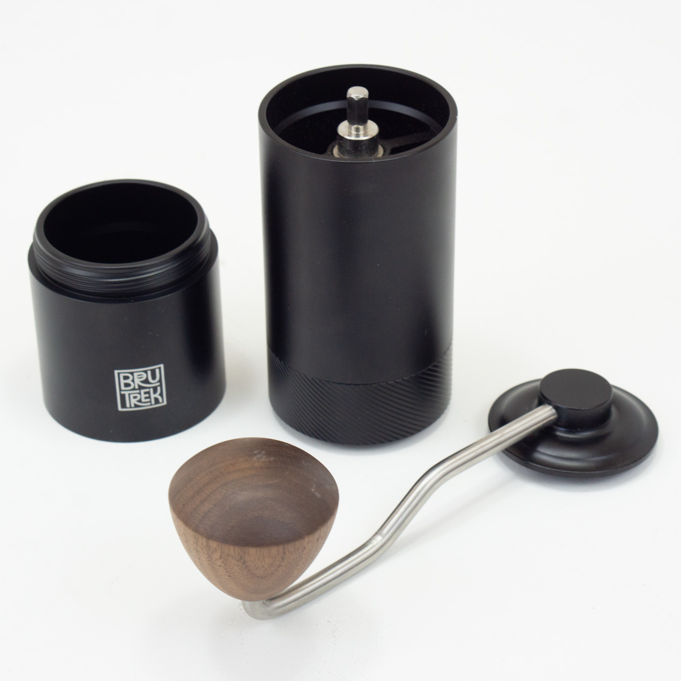 Black hand coffee grinder with wooden and metal handle on a white background