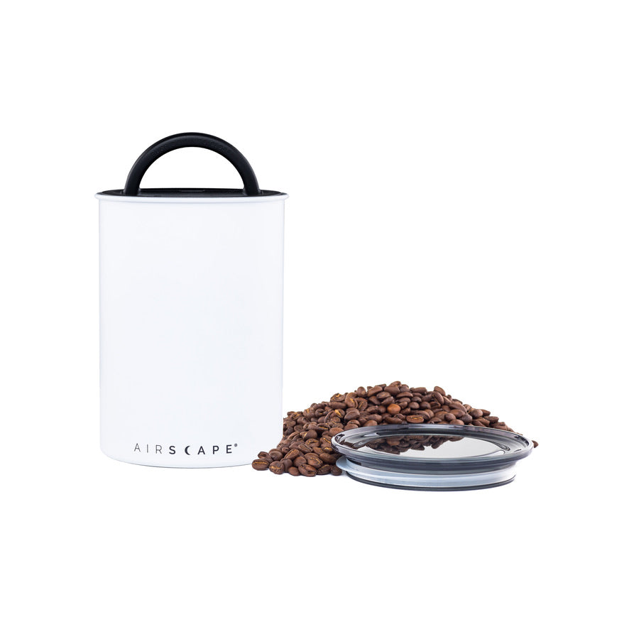 White air-tight container with black handle and lid, filled with coffee beans on a white background.